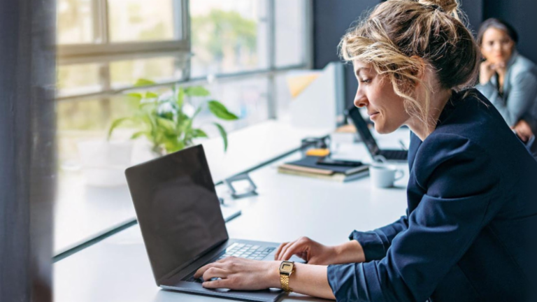 Young woman is working on a laptop in a modern office.