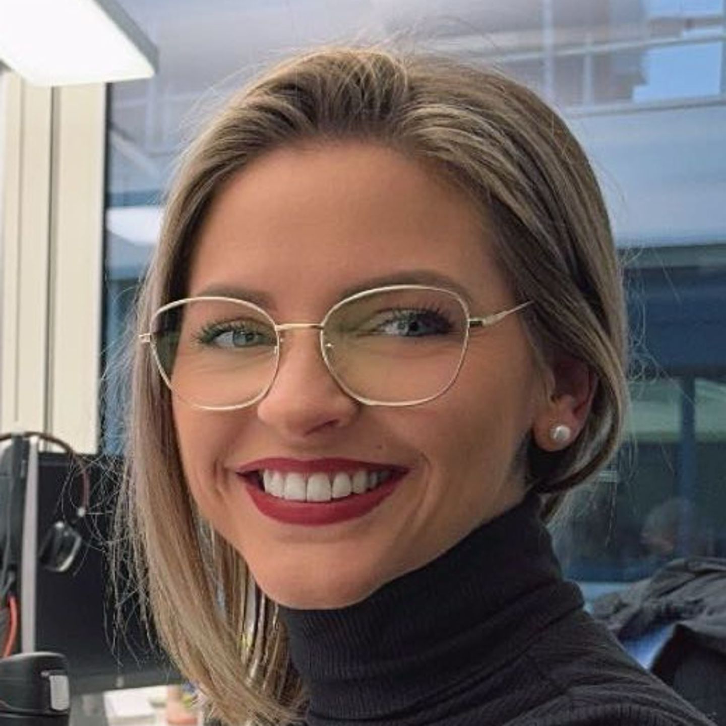 Genny Bollinger, a svájci EOS adósság-átstrukturálási szakértője szürke garbós pulóverben ül az asztalánál, és mosolyog a kamerába.