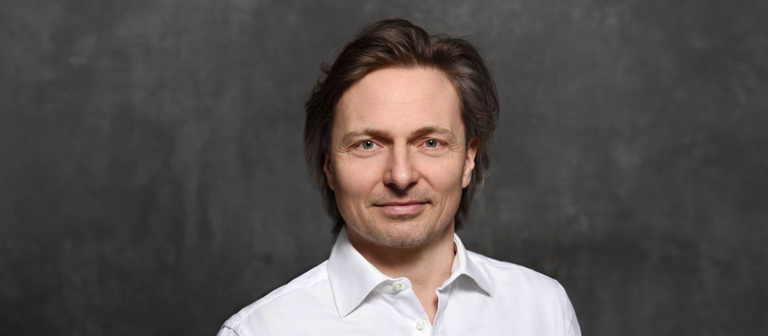 Janusch Skubatz kiberbiztonsági szakértő, az EOS Csoport információbiztonsági igazgatója, barna hajjal és fehér ingben.