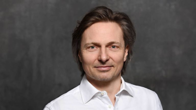 Janusch Skubatz kiberbiztonsági szakértő, az EOS Csoport információbiztonsági igazgatója, barna hajjal és fehér ingben.